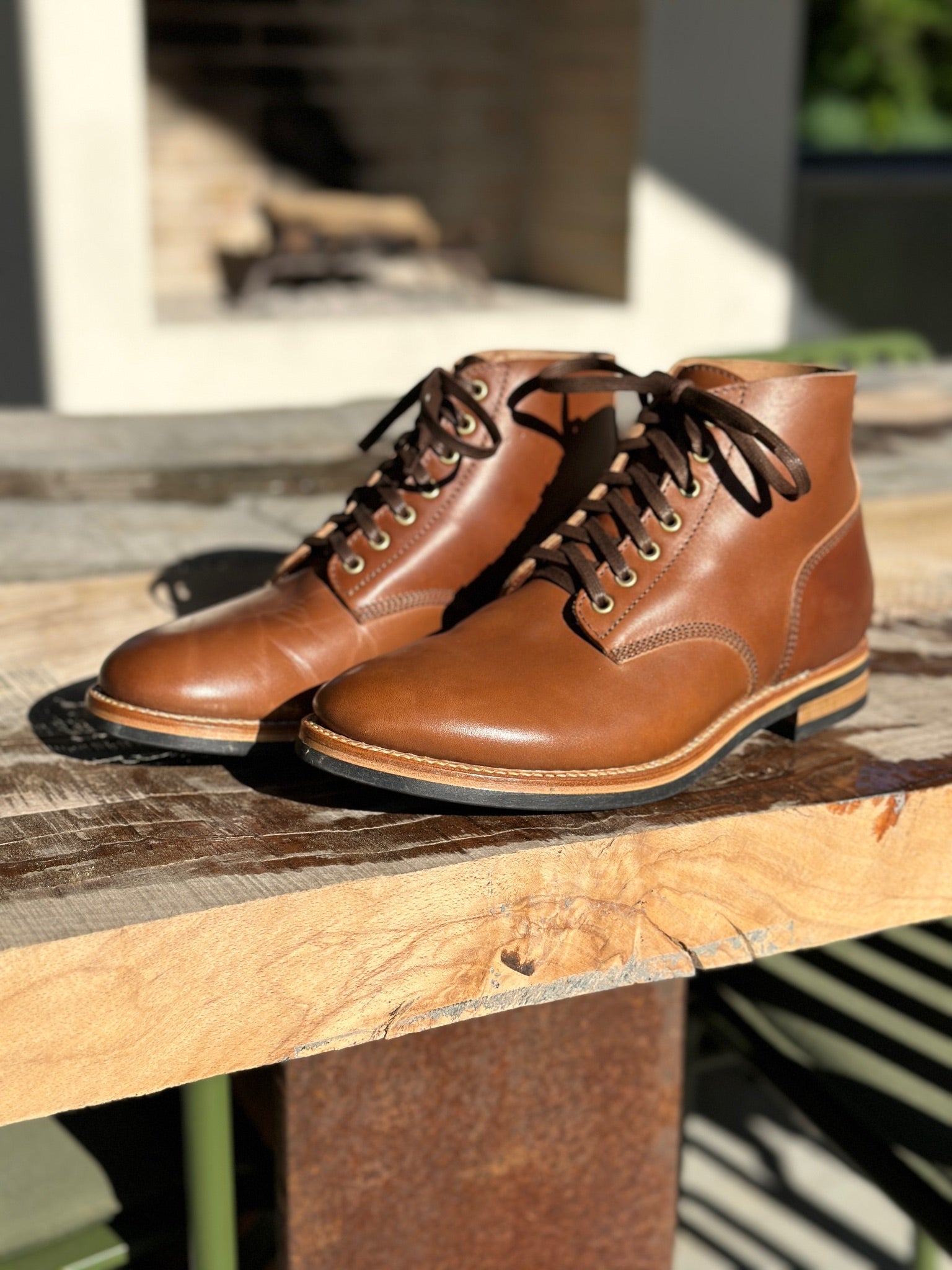 Brown leather boots on a wooden table