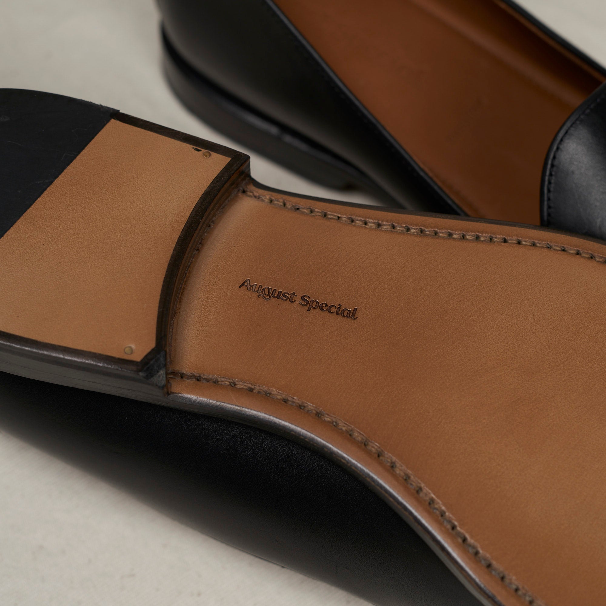 Sole view of August Special Augie Type-GP men's Goodyear-welted black calf loafer showing the hand-sewn welt and veg-tan leather outsole.