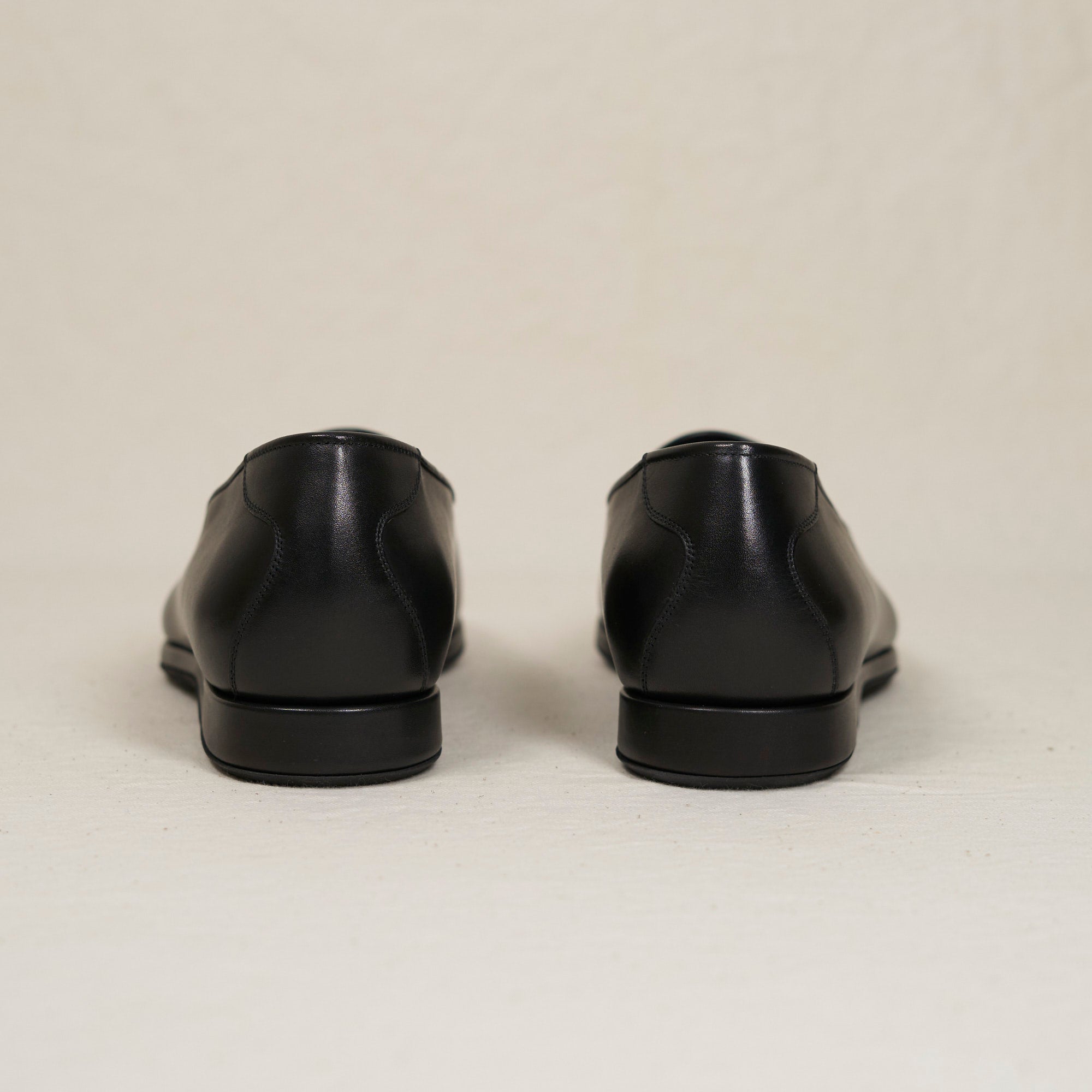 Back heel view of August Special Augie Type-P men's black veg-tan calf Blake loafer — cushioned insole, clean counter.