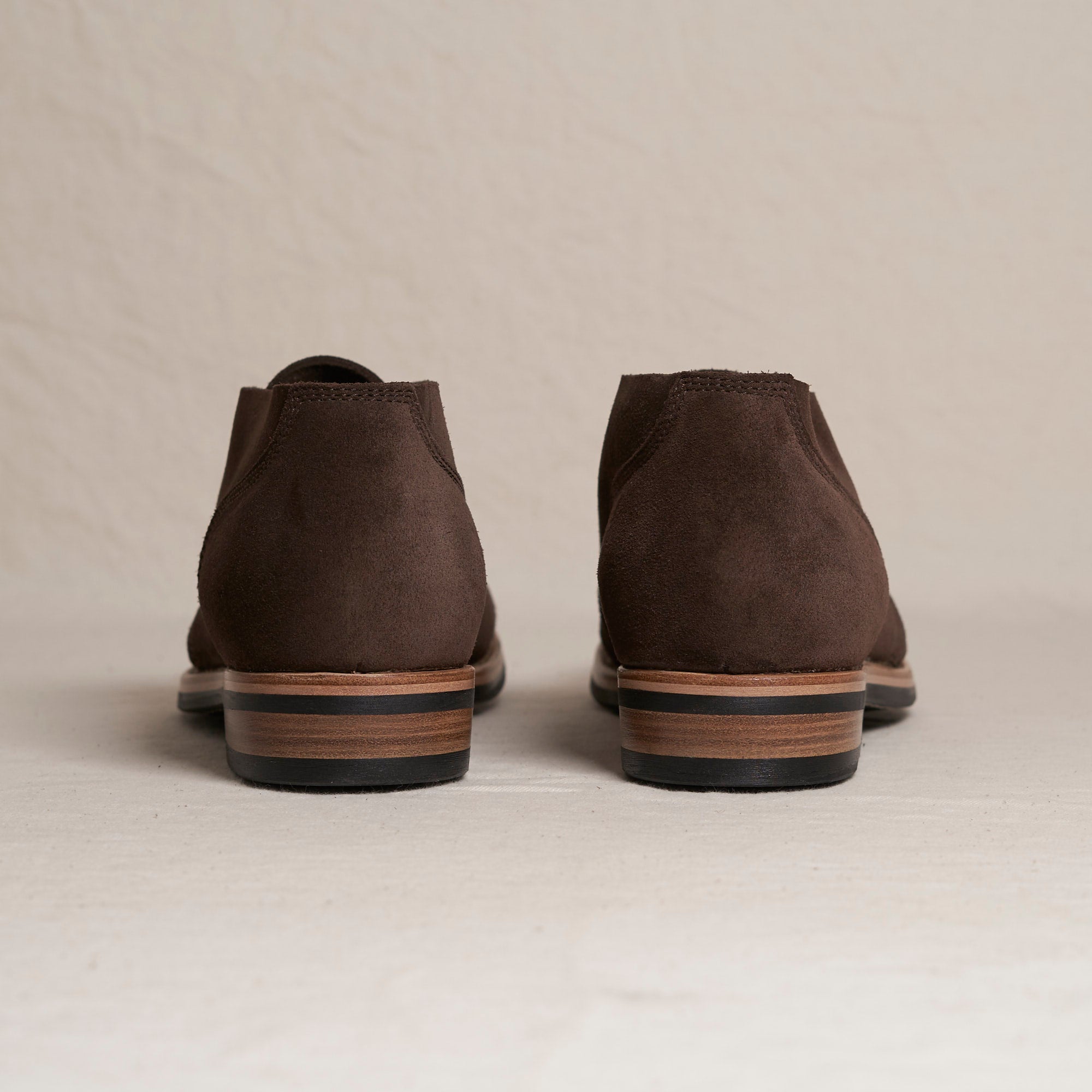 Back heel view of August Special Aviator men's chocolate suede Goodyear chukka — double-layer counter, Vibram outsole.