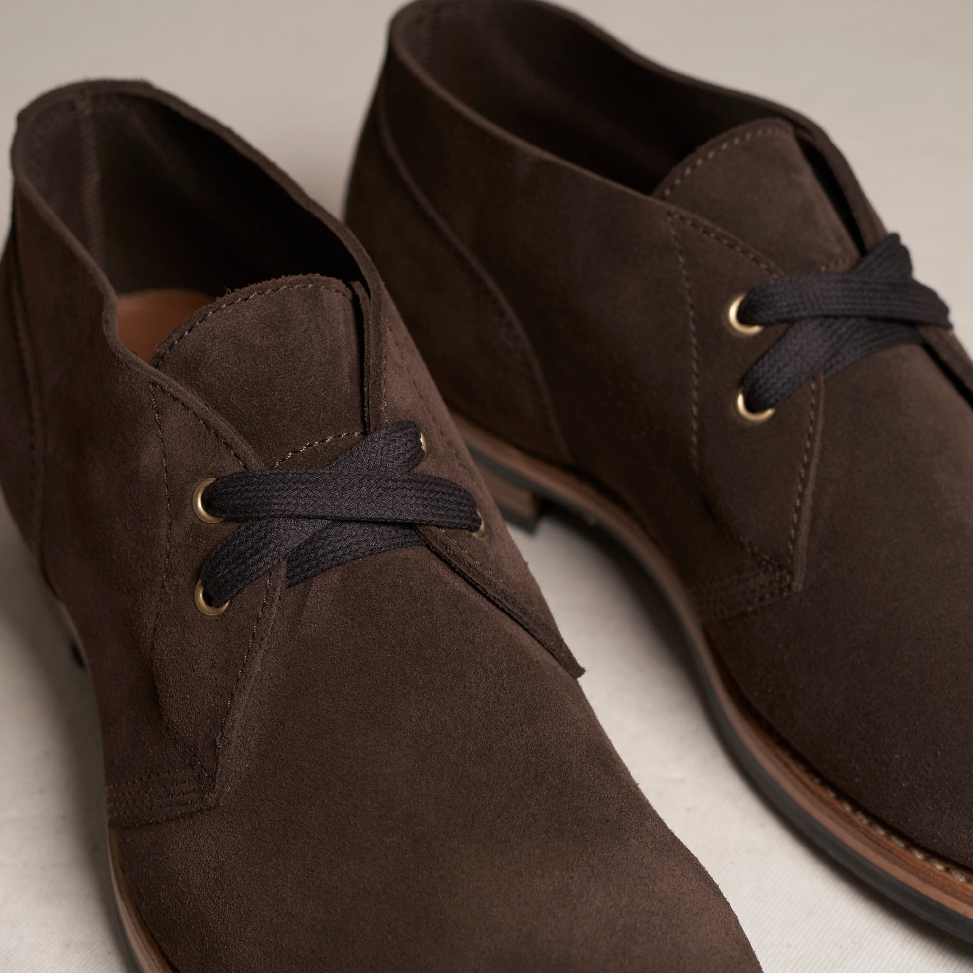Close detail of chocolate Maryam veg-tan suede and Goodyear welt on the August Special Aviator men's chukka boot.