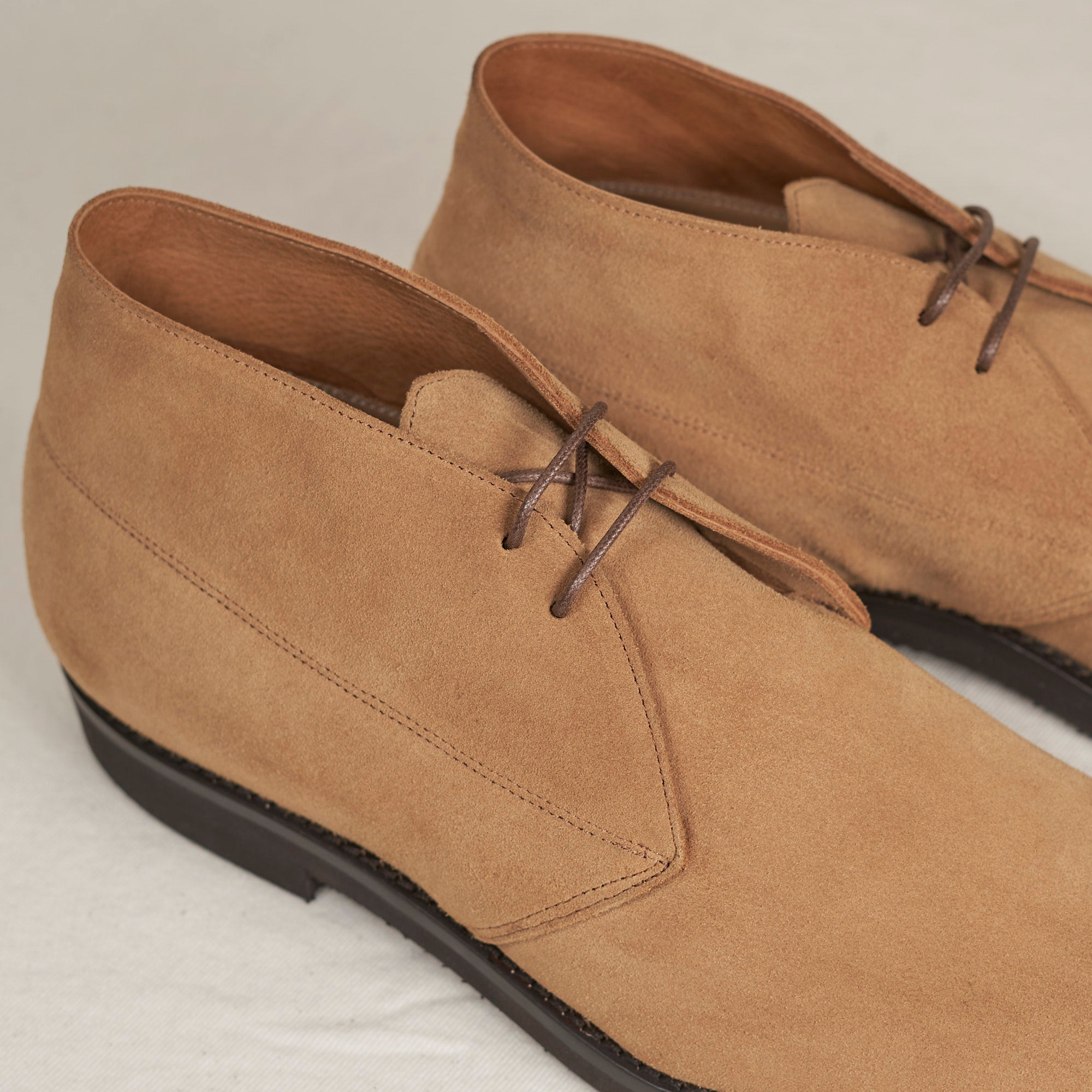 Close detail of caramel full-grain suede and Blake stitch on the August Special Voyager men's chukka boot.