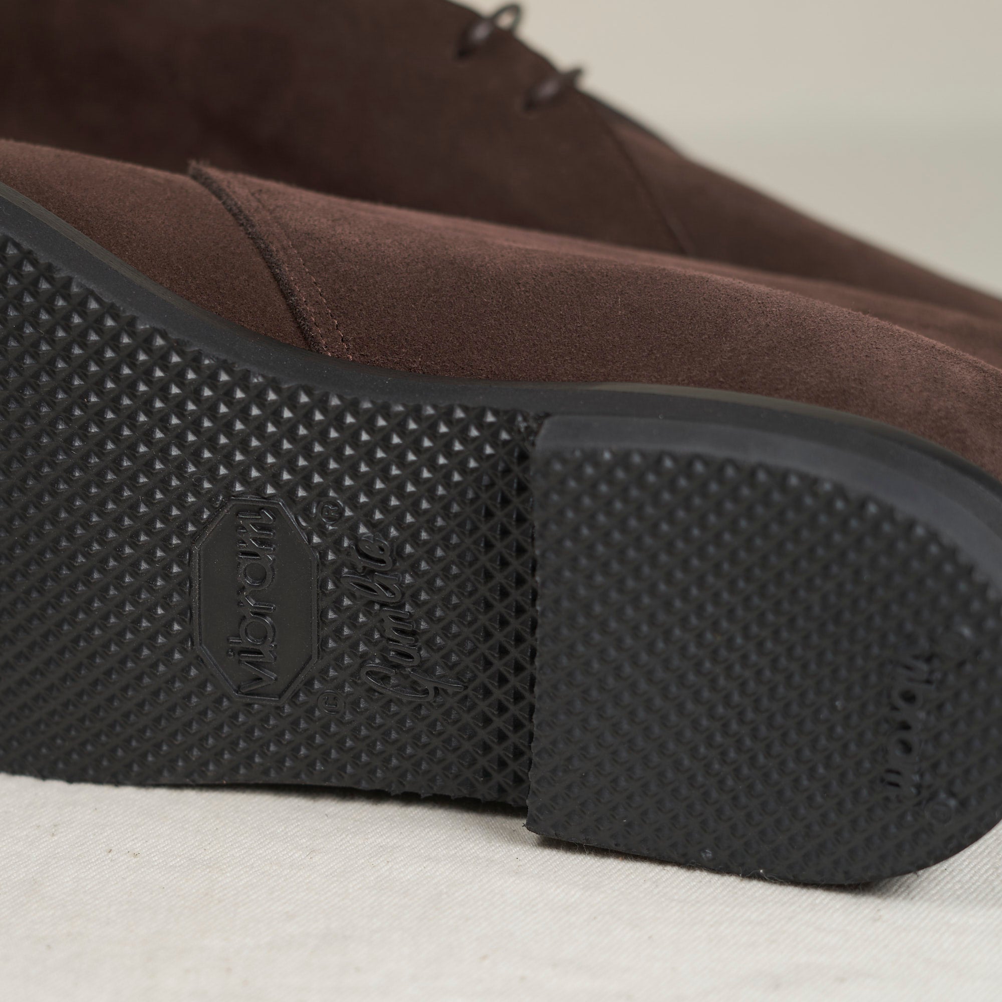 Sole view of August Special Voyager men's chocolate suede chukka — Vibram Gumlite outsole, Voyager Last fit.