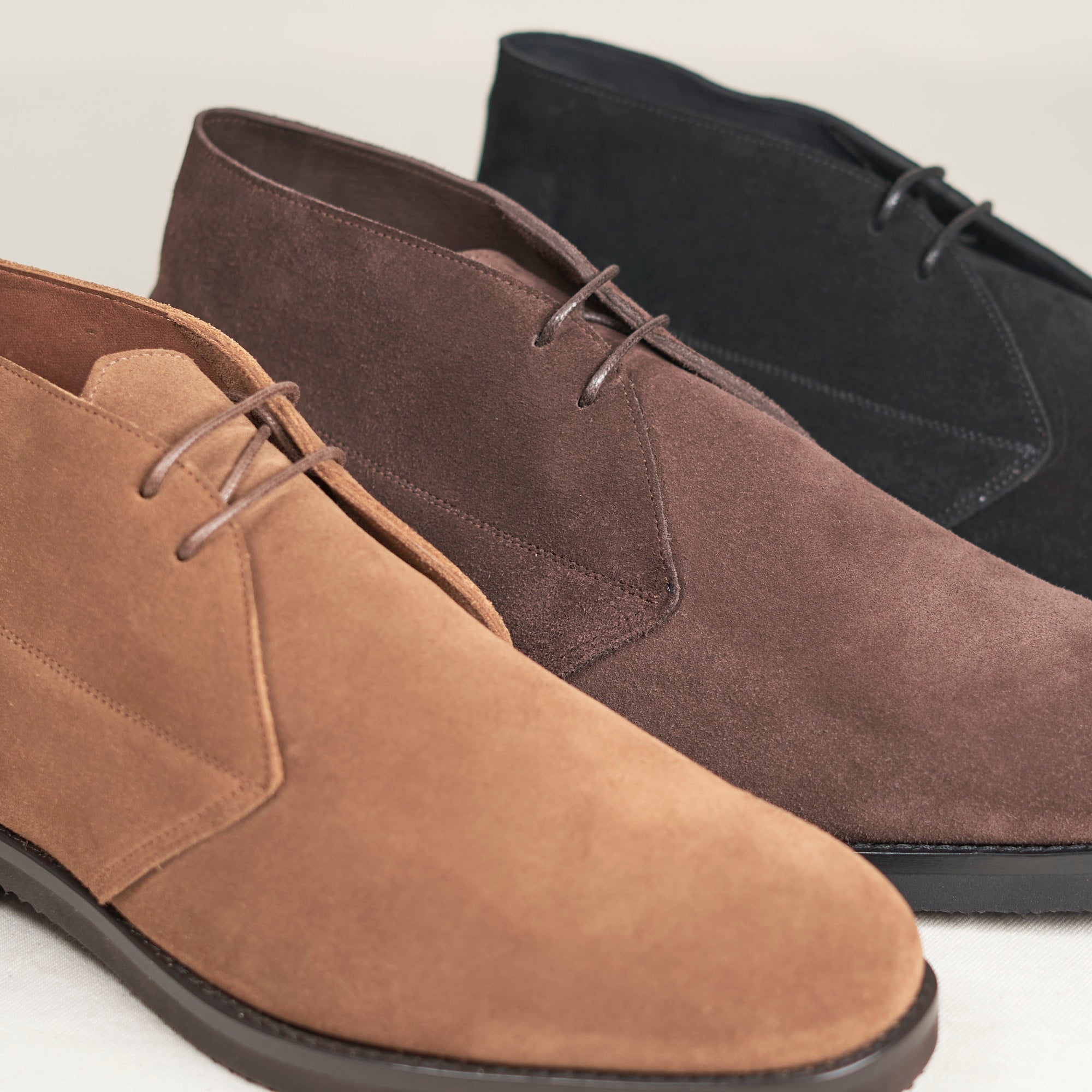Three pairs of August Special Voyager men's suede chukka boots in dark colorways — classic American style.