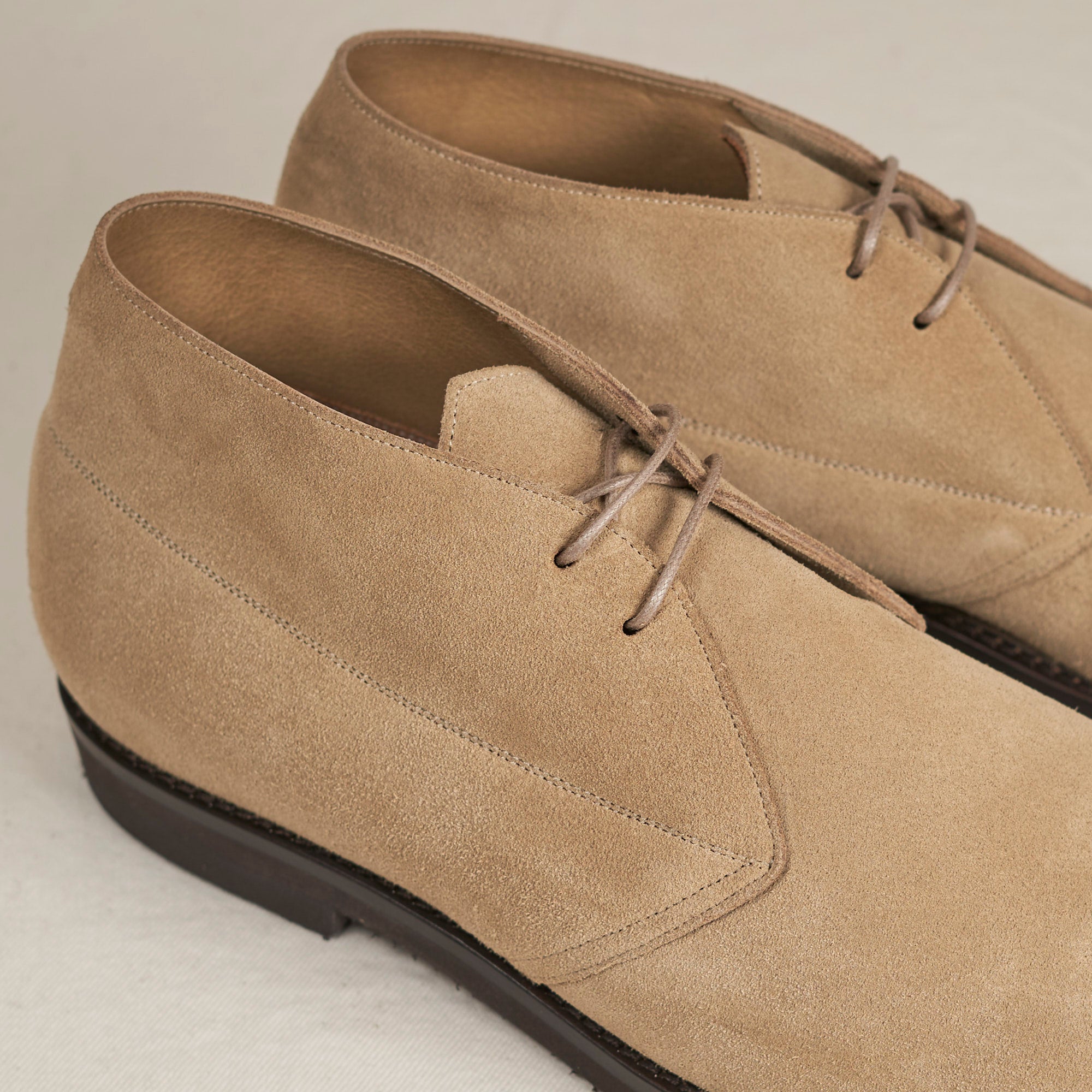 Close detail of sand full-grain suede and Blake stitch on the August Special Voyager men's chukka boot.