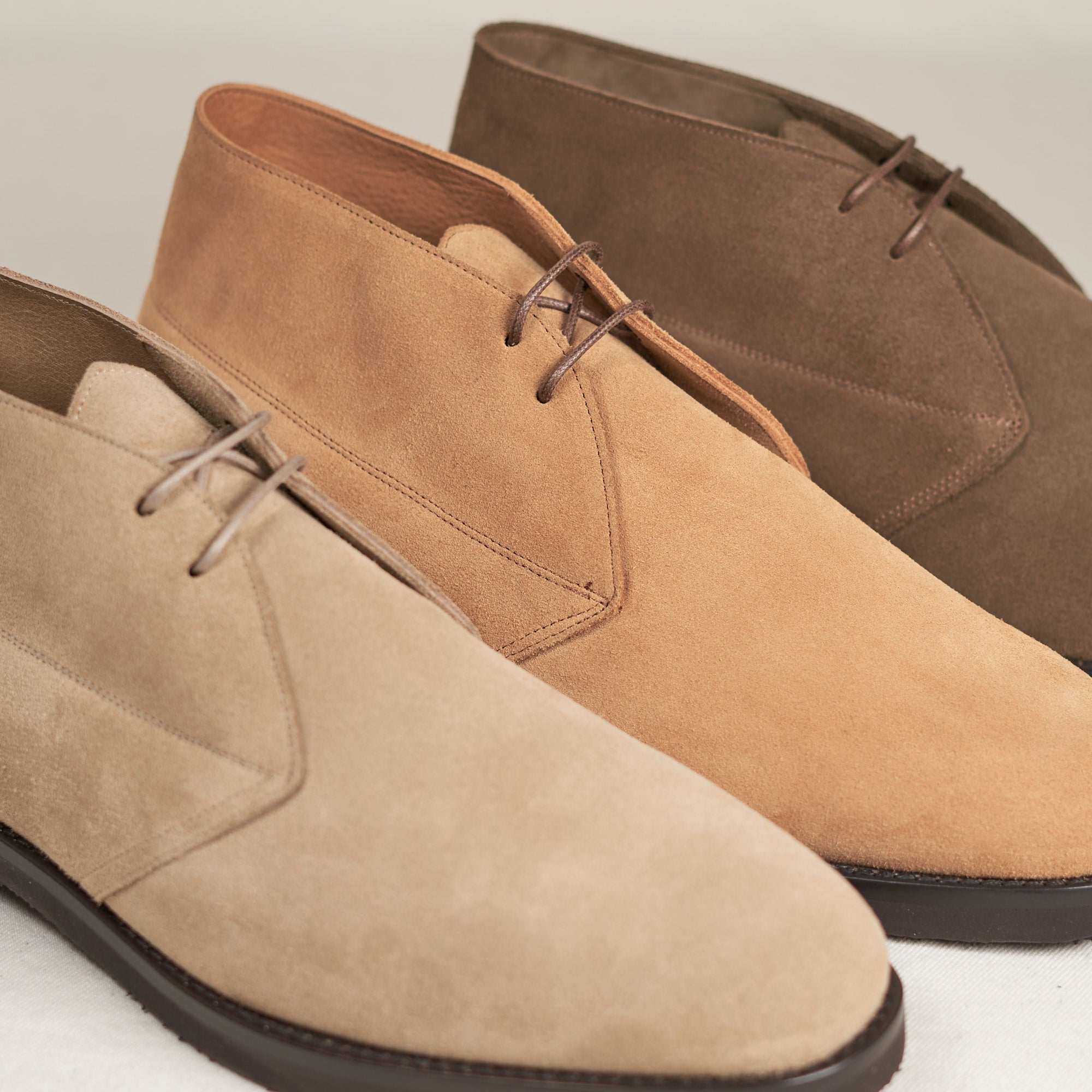 Three pairs of August Special Voyager men's suede chukka boots in warm colorways — classic American style.